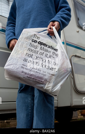 Shopper with cooperative supermarket Symphony Environmental biodegradable carrier bag UK Stock Photo