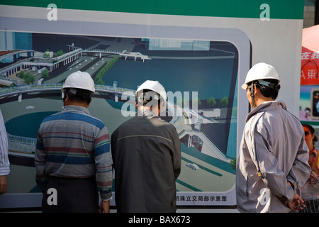 Construction engineers and surveyors in Shanghai China studying a plan. Stock Photo