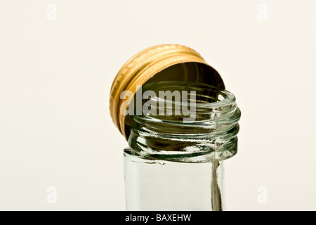 Glass bottle cut off at the neck with a golden bottle cap Stock Photo