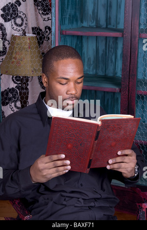 An African American man relaxing and reading a book Stock Photo