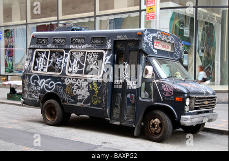 A graffitti covered mini bus sitting on a street in New York. Stock Photo