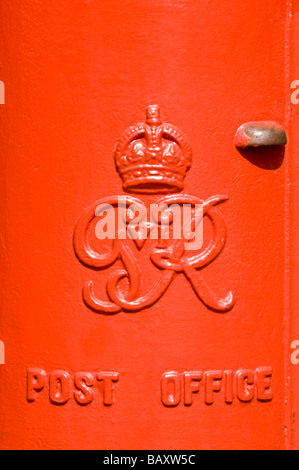 Vertical close up of an iconic red British pillar box - a free standing type A model from the reign of King George VI. Stock Photo