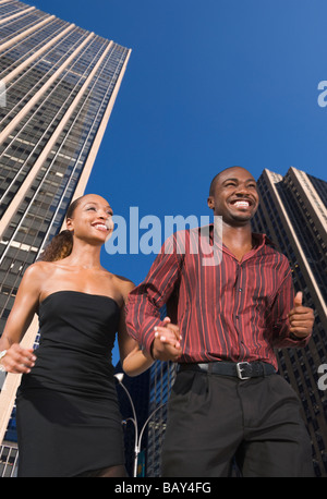 African couple holding hands in urban scene Stock Photo
