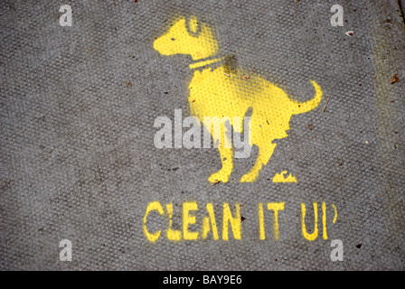 local council yellow stencilled image of defecating dog on pavement with phrase clean it up, in chiswick, west london, england Stock Photo