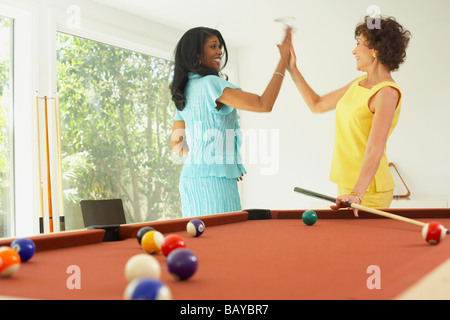 Multi-ethnic friends playing pool Stock Photo
