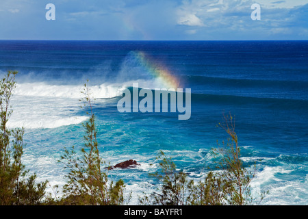 A rainbow forms off the spin drift from a large wave on Maui's North Shore, Hawaii. Stock Photo