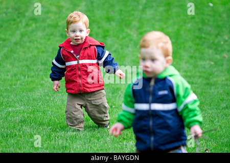 Twin boys playing outside on grass Stock Photo