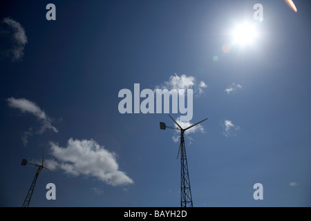 sun shining down on a two medium sized wind turbines in county tyrone northern ireland Stock Photo