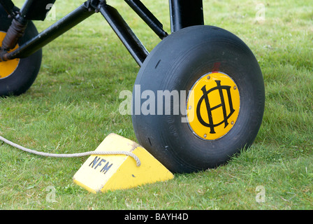 Wheel chocks and landing gear wheel  - de Havilland DH 82 Tiger Moth, a 1930s biplane. Stock Photo