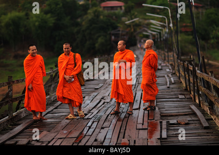 monks on wooden bridge over kheuan khao laem reservoir sangkhlaburi thailand Stock Photo