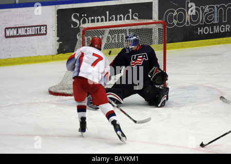 Russian player no 7 Kirill Kabanov scoring in a U18 ice-hockey game between USA and Russia. US goalie is no 33 Adam Murray. Stock Photo