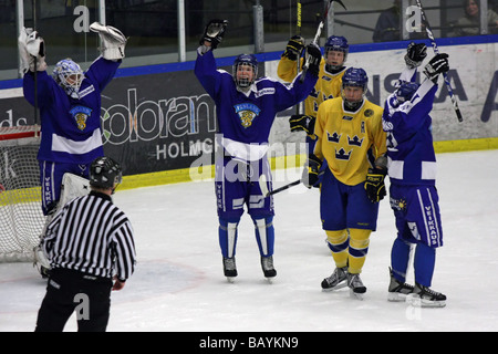 Team Finland celebrating a goal against Sweden in a U18 ice-hockey tournament. Stock Photo