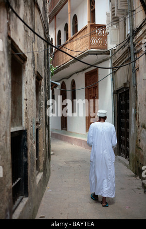 Boy walking down a narrow lane in Stone Town Zanzibar Stock Photo