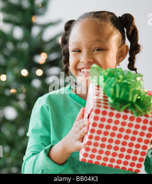 African American girl holding Christmas gift Stock Photo