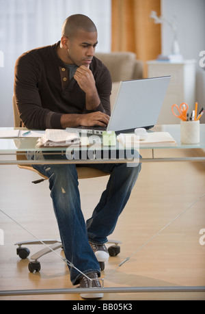 African American man working on laptop in home office Stock Photo