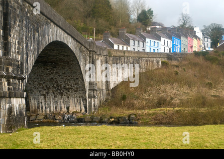 Old stone bridge at Llandeilo and the colourful houses behind Stock Photo