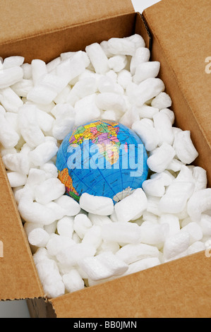 Globe in Open Cardboard Box Surrounded by Protective Packing Stock Photo