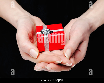 Hands Holding a Red Gift Box Stock Photo
