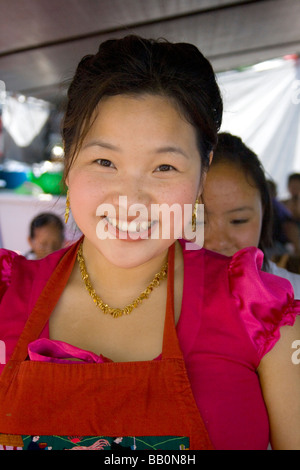 Happy attractive Hmong woman working in a food concession booth. Hmong Sports Festival McMurray Field St Paul Minnesota USA Stock Photo