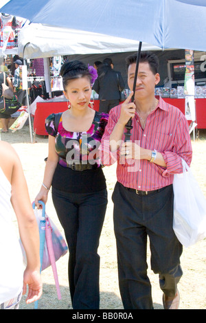 Attractive Hmong couple walking in the concession area. Hmong Sports Festival McMurray Field St Paul Minnesota USA Stock Photo