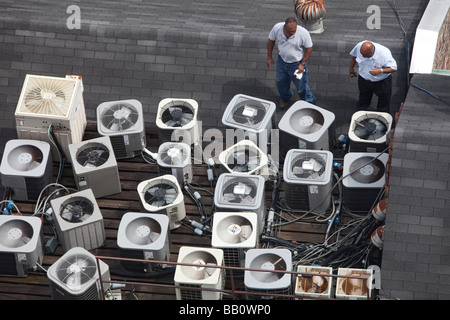 New Orleans Louisiana Two men inspect air conditioning equipment on the roof of a building in the French Quarter Stock Photo