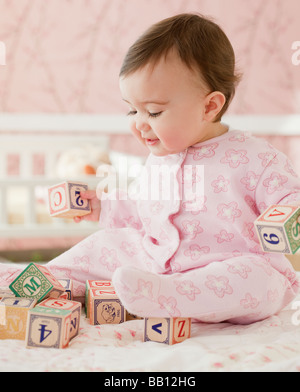 Mixed race baby girl playing with alphabet blocks Stock Photo