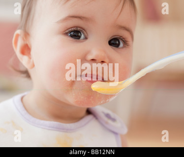 Mixed race baby girl eating Stock Photo
