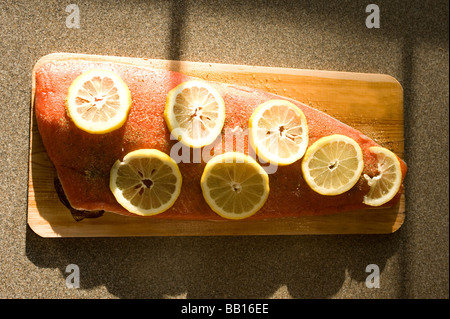 A fillet of sockeye salmon is seasoned and lying on a water soaked cedar plank and ready for the grill Stock Photo