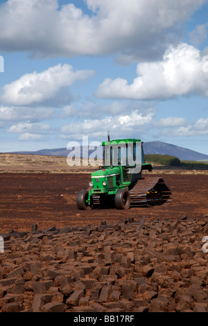 John Deere Tractor Peat Harvester extraction:  Harvesting Scottish sphagnum peat,  Tomintoul moorland peatland, Cairngorms National Park, Scotland, UK Stock Photo