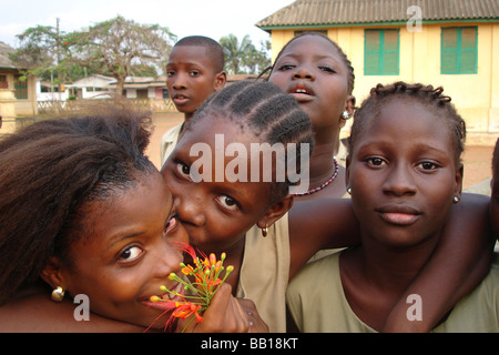 Benin Porto Novo Portrait of girlfriends hugging one kissing the other Stock Photo