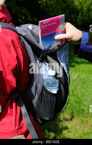 Rucksack mans hands packing map away Stock Photo