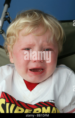 Blonde haired child crying with tears in his eyes. Stock Photo