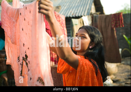Girl hanging clothes to dry, Mipur Village, outside of Dhaka, Bangladesh. Stock Photo