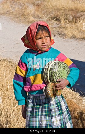 Young girl receives fruit and school supplies given as gifts in the Tarahumara village of San Alonso in Copper Canyon Mexico Stock Photo