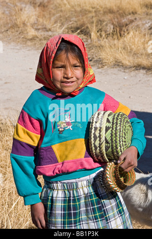 Young girl receives fruit and school supplies given as gifts in the Tarahumara village of San Alonso in Copper Canyon Mexico Stock Photo