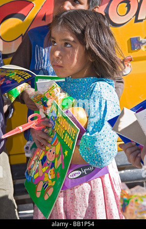 Young girl receives fruit and school supplies in the Tarahumara village of San Alonso in Copper Canyon Stock Photo