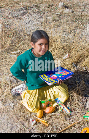 Young girl receives fruit and school supplies in the Tarahumara village of San Alonso in Copper Canyon Stock Photo