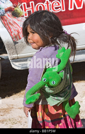 Young girl wearing stuffed toy receives fruit and school supplies in the Tarahumara village of San Alonso Copper Canyon Stock Photo