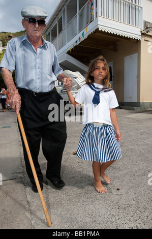 Young girl leads elderly man with stick Saint Louis Festival Corossol St Barts Stock Photo