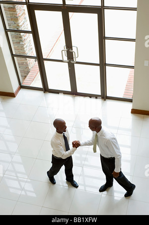 two businessmen in a handshake at the office Stock Photo - Alamy