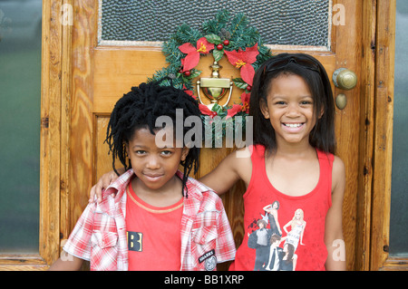 Boy and girl in front of door at Christmas, Pietermaritzburg, KwaZulu-Natal Province, South Africa Stock Photo