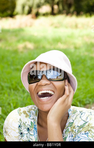Woman listening to a portable music player in a park,  Johannesburg, Gauteng Province, South Africa Stock Photo