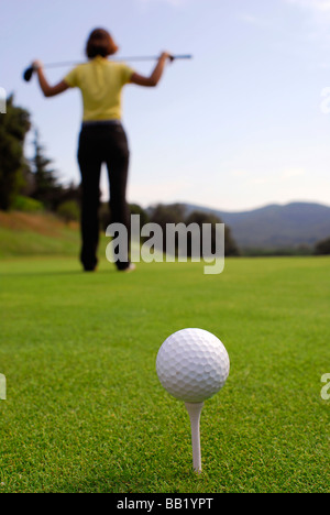 Young woman golfer observing terrain and conditions before hitting Stock Photo