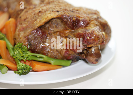 Fresh Traditional Roast Leg of Lamb With Vegetables Including Broccoli And Carrots Isolated Against A White Background With No People Stock Photo