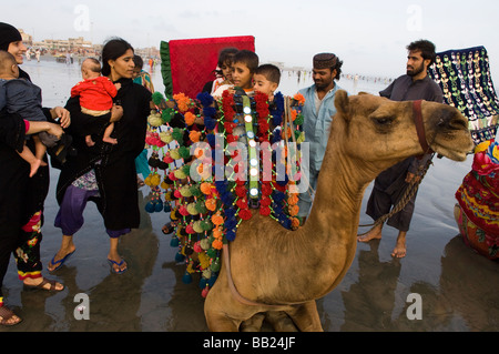 Pakistani s enjoying the camels and the sea on Clifton beach Karachi Pakistan Stock Photo