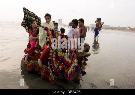 Pakistani s enjoying the camels and the sea on Clifton beach Karachi Pakistan Stock Photo