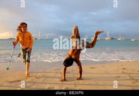 St Martin Grand Case boy doing handstands on the beach Stock Photo