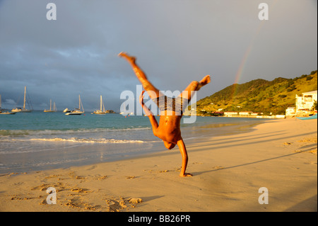 St Martin Grand Case boy doing handstands on the beach Stock Photo