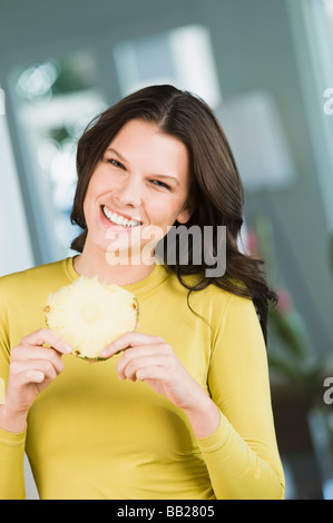 Woman holding a slice of pineapple Stock Photo