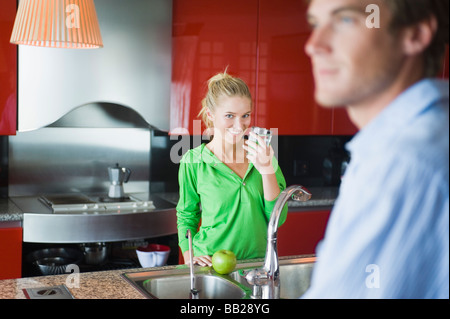Woman holding a glass of water in the kitchen Stock Photo